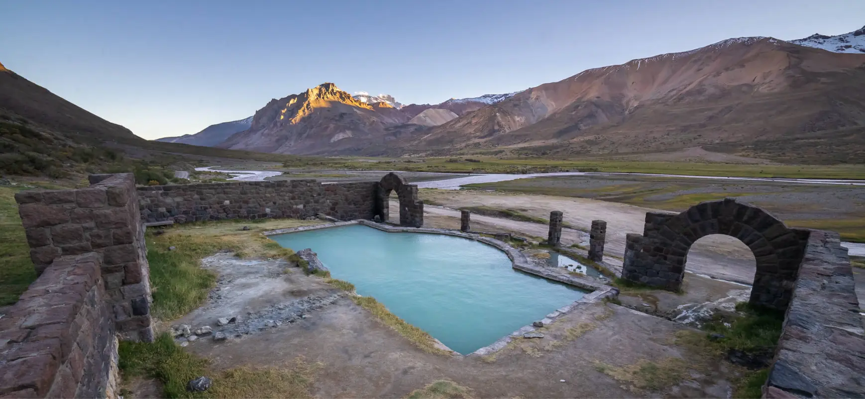 Ruinas del Sosneado con una pileta y montañas de fondo